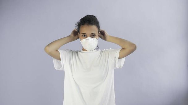 Young Afro-American Girl wearing face mask on grey background - Photo, Image
