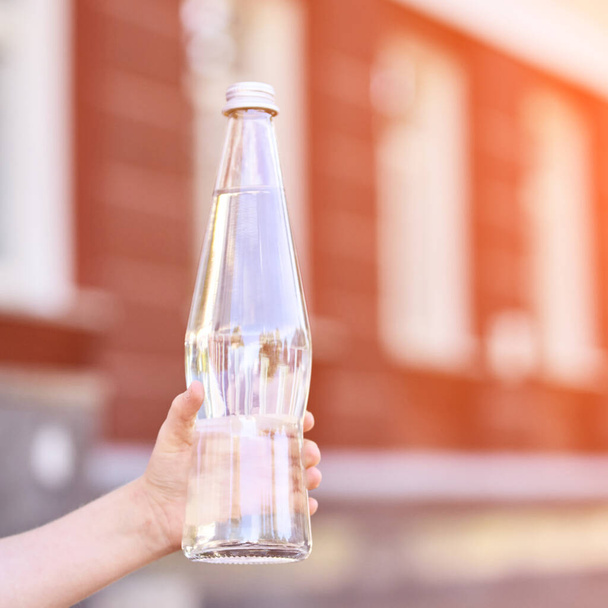 Little girl holding water bottle. Outdoor training. Thirsty. Glass drink - Valokuva, kuva
