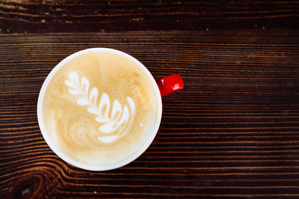 Café fresco con latte arte en taza roja - Foto, imagen