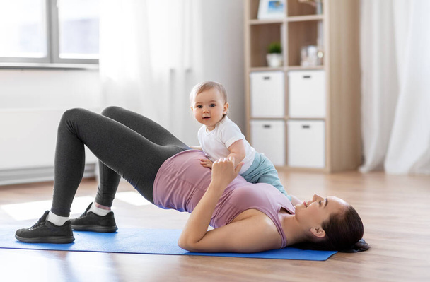 happy mother with little baby exercising at home - Fotografie, Obrázek