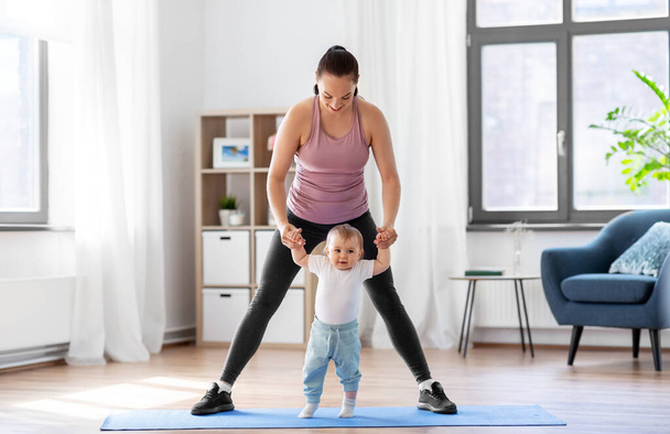 happy mother with little baby exercising at home - Φωτογραφία, εικόνα