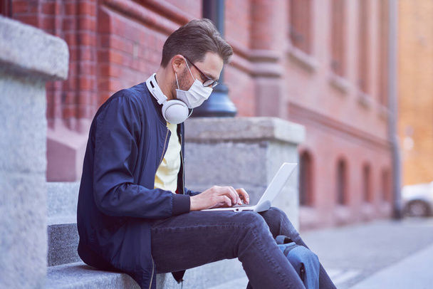 Muž student v kampusu v masce v důsledku pandemie koronaviru - Fotografie, Obrázek