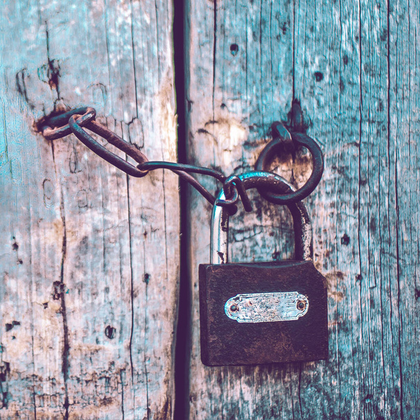 Porta de madeira azul pálida velha com uma fechadura e uma corrente. Estilo Boho
 - Foto, Imagem