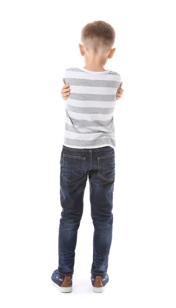 Smutný malý chlapec s autistickou poruchou na bílém pozadí, pohled zezadu - Fotografie, Obrázek