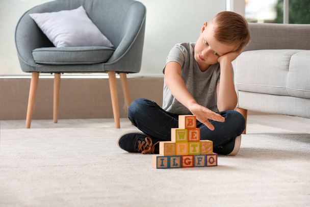 Маленький хлопчик з аутичним розладом грає з кубиками вдома
 - Фото, зображення