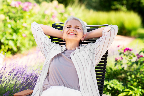 happy senior woman resting at summer garden - Foto, Imagem