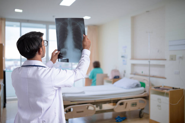 Doctor controleren borst x-ray film op ziekenhuis achtergrond - Foto, afbeelding