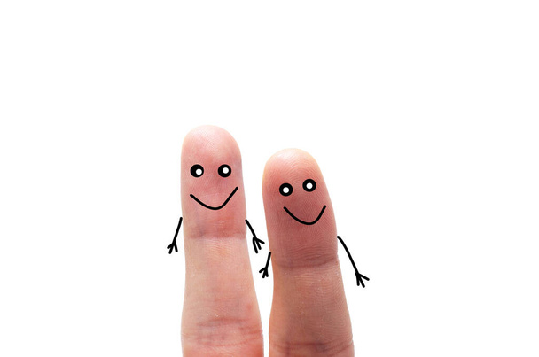 Two fingers on a white background with and without a face. Various emotions, joy, sadness, anger are depicted on the fingers - Zdjęcie, obraz