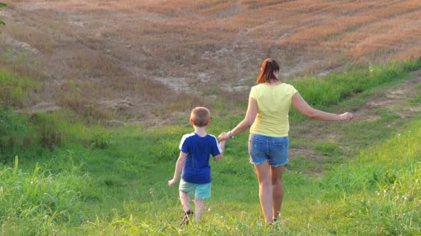 Matka i syn biegną razem na łąkę. - Materiał filmowy, wideo