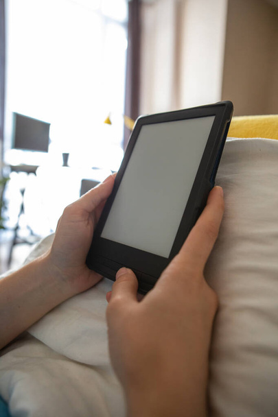 електронна книга з порожнім екраном в руках жінки. покладання в ліжку
 - Фото, зображення