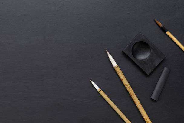 Japon geleneksel yazı fırçasını siyah masaya yakın çekim. Üst Manzara. düz yat - Fotoğraf, Görsel