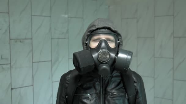 壁近くのガスマスクの男-化学兵器からの保護、ウイルスの流行 - 映像、動画