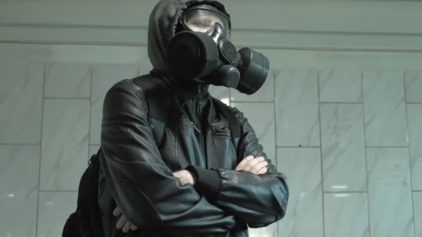 człowiek w masce gazowej w pobliżu ściany - ochrona przed bronią chemiczną, epidemia wirusa - Materiał filmowy, wideo