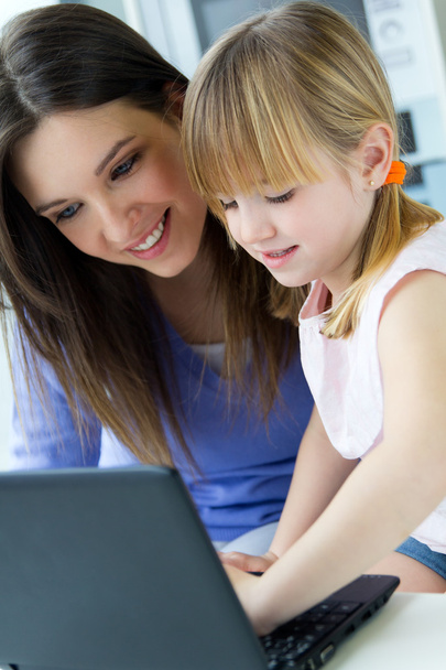 Mother and daughter using laptop in the kitchen - Foto, Bild