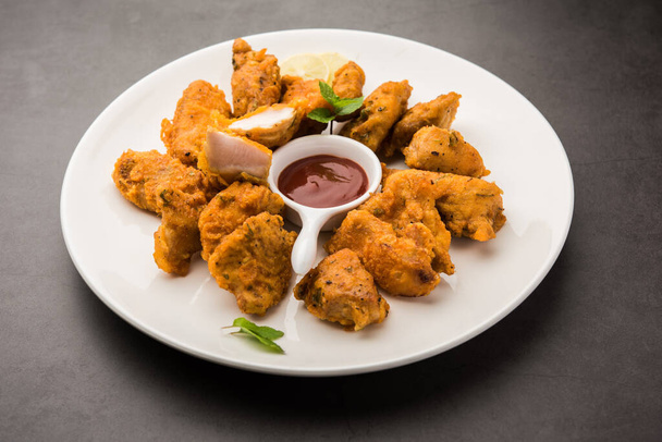 Куриный пакора или пакода или оладьи является популярной индийской закуской, в которой бескостные куски курицы маринованы, а затем покрыты смесью бессана, рисовой муки, кукурузной муки и яйца - Фото, изображение