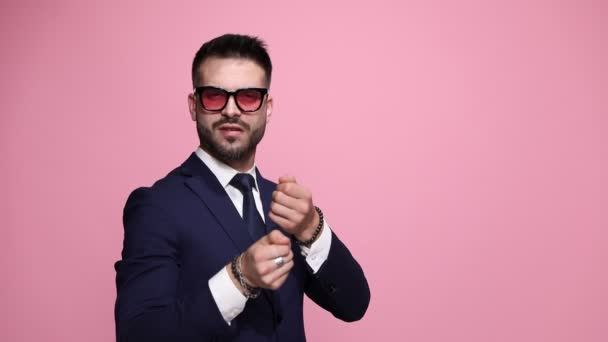 attraktiver Geschäftsmann, der ein unsichtbares Seil zieht, seine Gefangennahme betrachtet, dann seine Finger küsst und seine Küsse auf rosa Hintergrund überall verteilt - Filmmaterial, Video