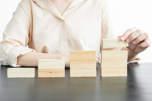 Hands of businesswomen playing wooden block game. Concept Risk of management and strategy plans for business growth and success. - Foto, Imagen
