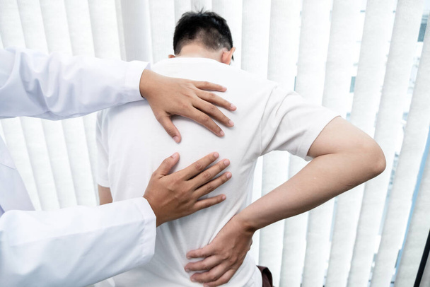男性患者は診察と治療のために腰痛を持つ理学療法士に相談した。リハビリテーション理学療法の概念. - 写真・画像