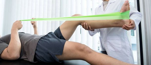 Οι άνδρες ασθενείς συμβουλεύθηκαν φυσιοθεραπευτές με προβλήματα πόνου στο γόνατο για εξέταση και θεραπεία. Φυσιοθεραπεία αποκατάστασης. - Φωτογραφία, εικόνα