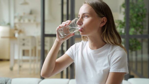 Female drinking from a glass of water. Health care concept photo, lifestyle, close up - Фото, изображение