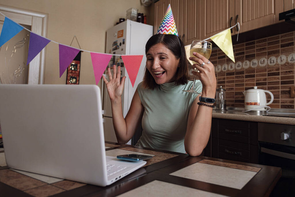 Дівчинка святкує день народження в карантинному часі. Жінка святкує свій день народження через відео-дзвінок віртуальній вечірці з друзями. Автентичні прикрашені домашні роботи. Спалах коронавірусу 2020. - Фото, зображення