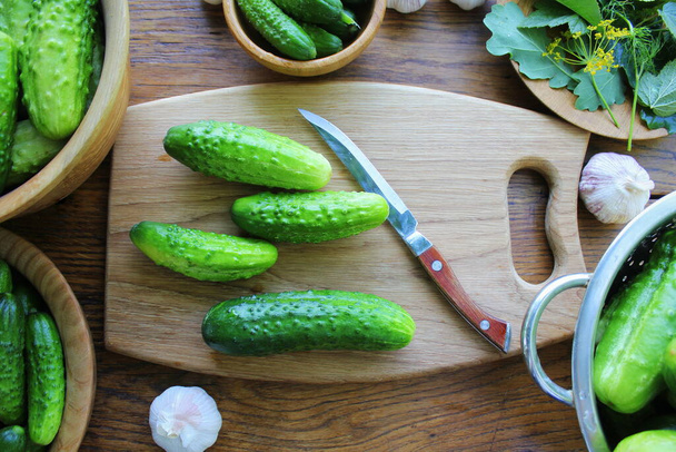 Cucumber canning concept. fermented pickled cucumbers, dill , garlic on wooden table . - Photo, Image