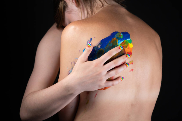 Picture of woman messing up rainbow on nude back - Фото, изображение