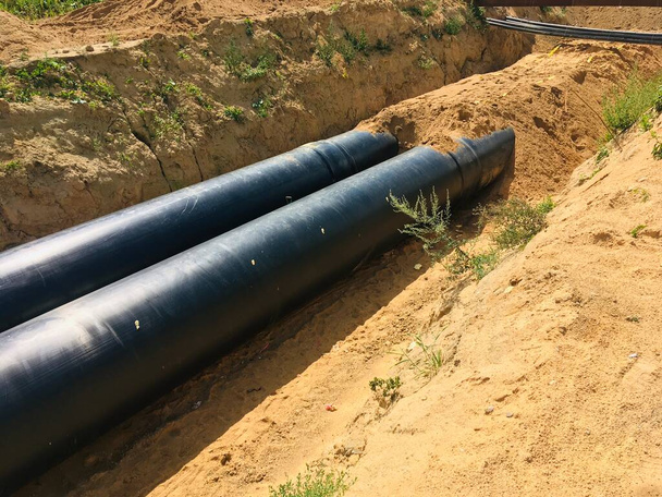 új szigetelt vízvezetékek az árok építési területén . - Fotó, kép