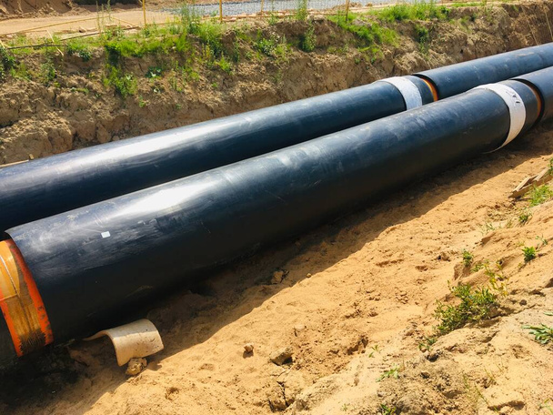 новые изолированные водопроводные трубы на месте строительства траншеи . - Фото, изображение