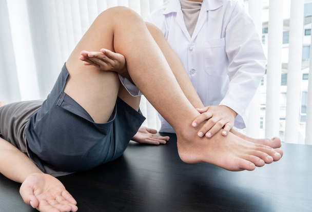 I pazienti di sesso maschile consultavano fisioterapisti con problemi al ginocchio per l'esame e il trattamento. Concetto di fisioterapia riabilitativa. - Foto, immagini