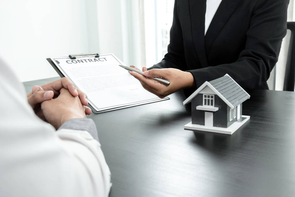 Immobilienmakler mit Hausmodellen sprechen mit Kunden über die Anmietung von Häusern und den Abschluss einer Hausratversicherung. Miet- und Versicherungskonzepte. - Foto, Bild