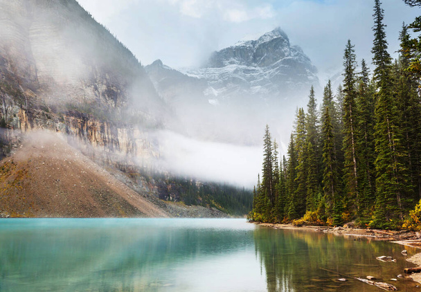 Cena serena junto ao lago da montanha no Canadá com reflexo das rochas na água calma. - Foto, Imagem