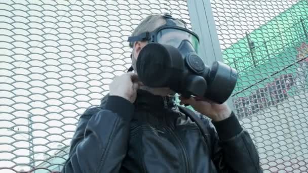 Man met gasmasker bij een epidemie die buiten staat. chemisch wapen, virusbescherming - Video