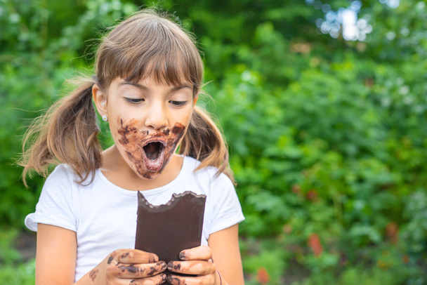 A criança come um chocolate. Foco seletivo. Pessoas
. - Foto, Imagem