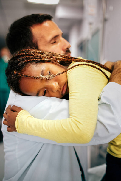 Doctor comforting, supporting a worried sad young girl in hospital - Foto, Imagem