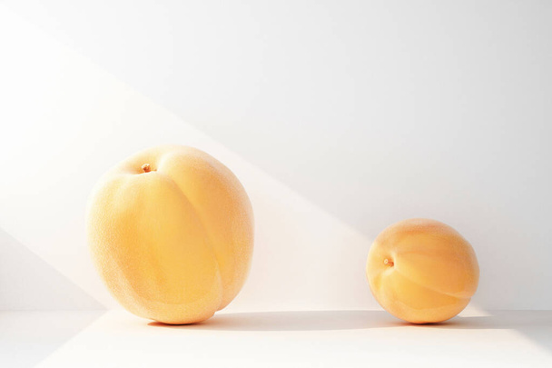 comparison of small and large peach in a ray of light. 3d rendering - Foto, afbeelding