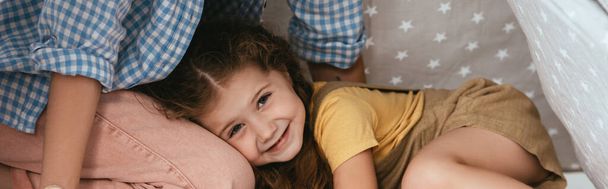 Ausgeschnittener Blick auf Kindermädchen und entzückendes, glückliches Kind, das auf ihrem Schoß liegt, Panoramaaufnahme - Foto, Bild
