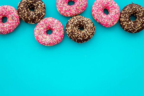 Colorful donuts pink and chocolate icing. Flat lay of bakery, above view - Фото, изображение