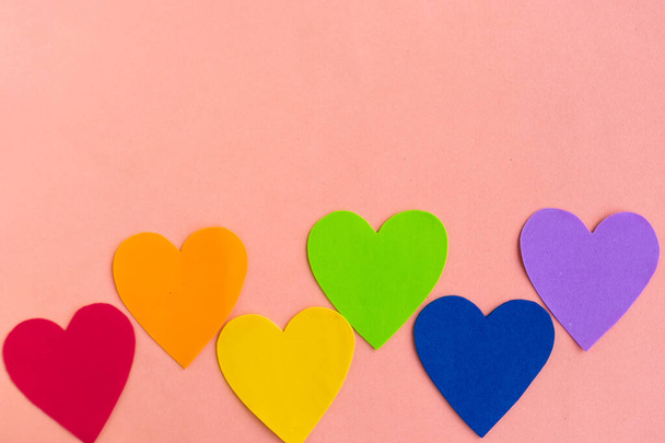 Hearts in lgbtq colors on pastel pink background, top view, copy space - Fotografie, Obrázek