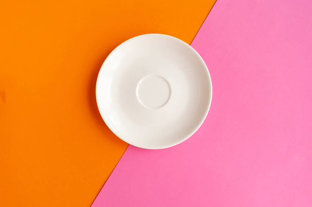 Empty plate on orange and pink background. Copy space for the text. Minimal concept - Photo, Image