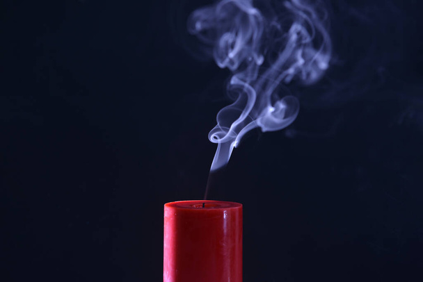 Candela rossa con fumo bianco su sfondo nero  - Foto, immagini