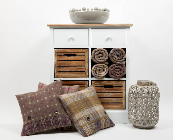 Chest of drawers, cushions, throws, ornaments and wicker candle holder on a white background - Photo, Image