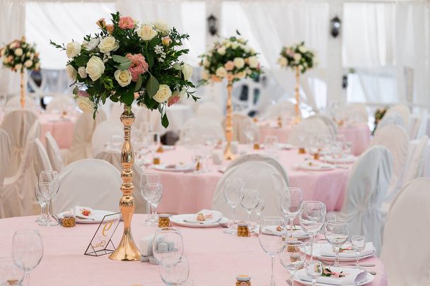 Όμορφο σετ διακόσμησης για γαμήλιο πάρτι. Σχεδιασμός από λουλούδι, ποικιλία γυαλί πολυτελείας και κερί. Επιλεκτική εστίαση. πανέμορφη γαμήλια καρέκλα και τραπέζι για καλό φαγητό σε εξωτερικούς χώρους πανέμορφη γαμήλια καρέκλα και τραπέζι για καλό φαγητό σε εξωτερικούς χώρους - Φωτογραφία, εικόνα