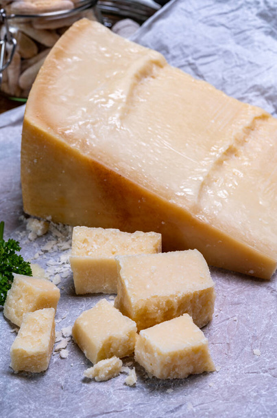 Big wedge of parmigiano-reggiano parmesan hard Italian cheese made from cow milk or Grana Padano  close up - Photo, Image