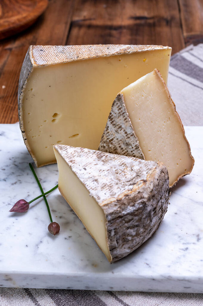 A francia Alpokban tehéntejből készült, tomme de montagne vagy tomme de savoie sajtdarabok. - Fotó, kép