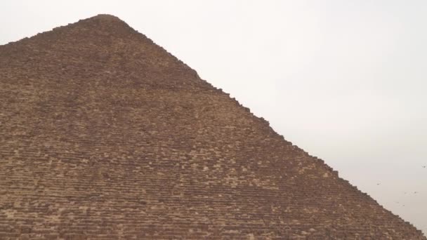 Cheopsova pyramida na pozadí zatažené oblohy. Ptáci létají po obloze. Cheops Pyramida, Velká pyramida v Gíze - největší z egyptských pyramid - Záběry, video