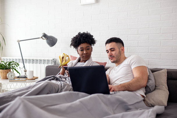 Giovane coppia che naviga su internet a letto - Foto, immagini
