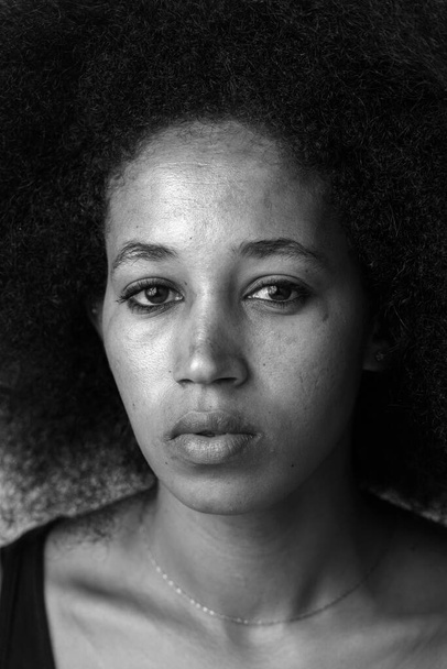Studio shot της νεαρής όμορφης Αφρικανικής γυναίκας με μαλλιά Afro σε λευκό φόντο σε μαύρο και άσπρο - Φωτογραφία, εικόνα