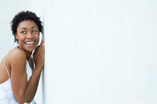 Smiling woman leaning against wall portrait - Фото, изображение