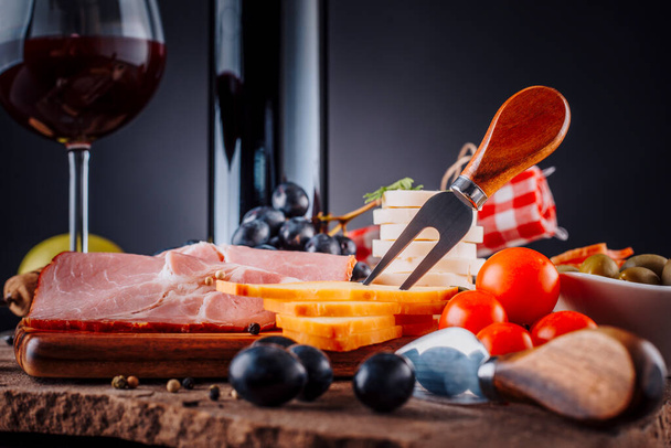 Red wine and appetizers on a black background - Photo, Image